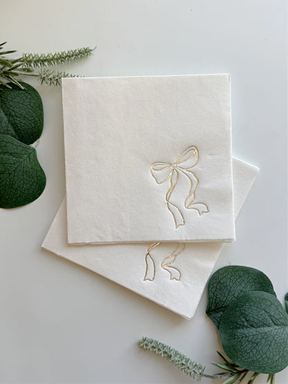 gold bow on white cocktail napkin for an elegant she's tying the knot bridal shower - shop for tasteful bridal shower decor at EnFete
