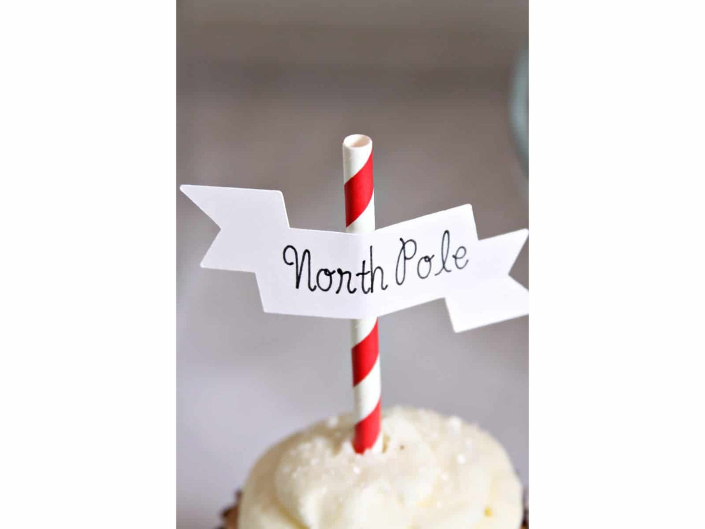 North Pole Cupcake Topper on a cupcake with sparkly sprinkles