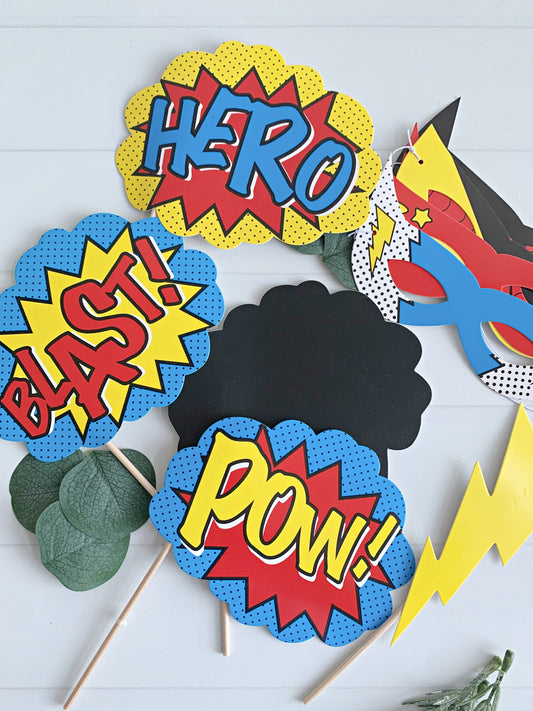 Superhero-themed photo props with 'HERO', 'BLAST!', and 'POW!' text on a white background.