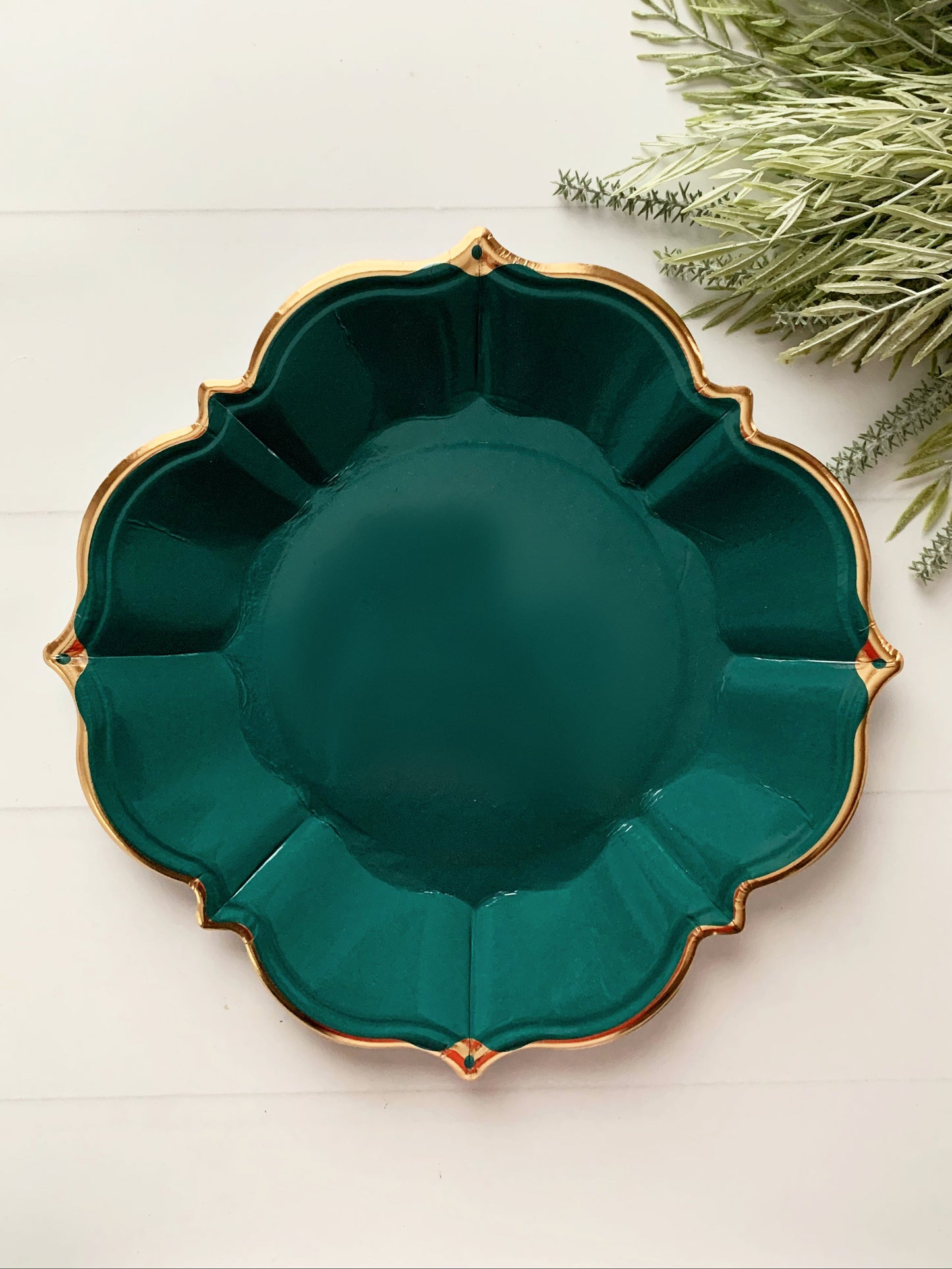Emerald Green decorative party plate with gold rim on a light background made of paper party supplies