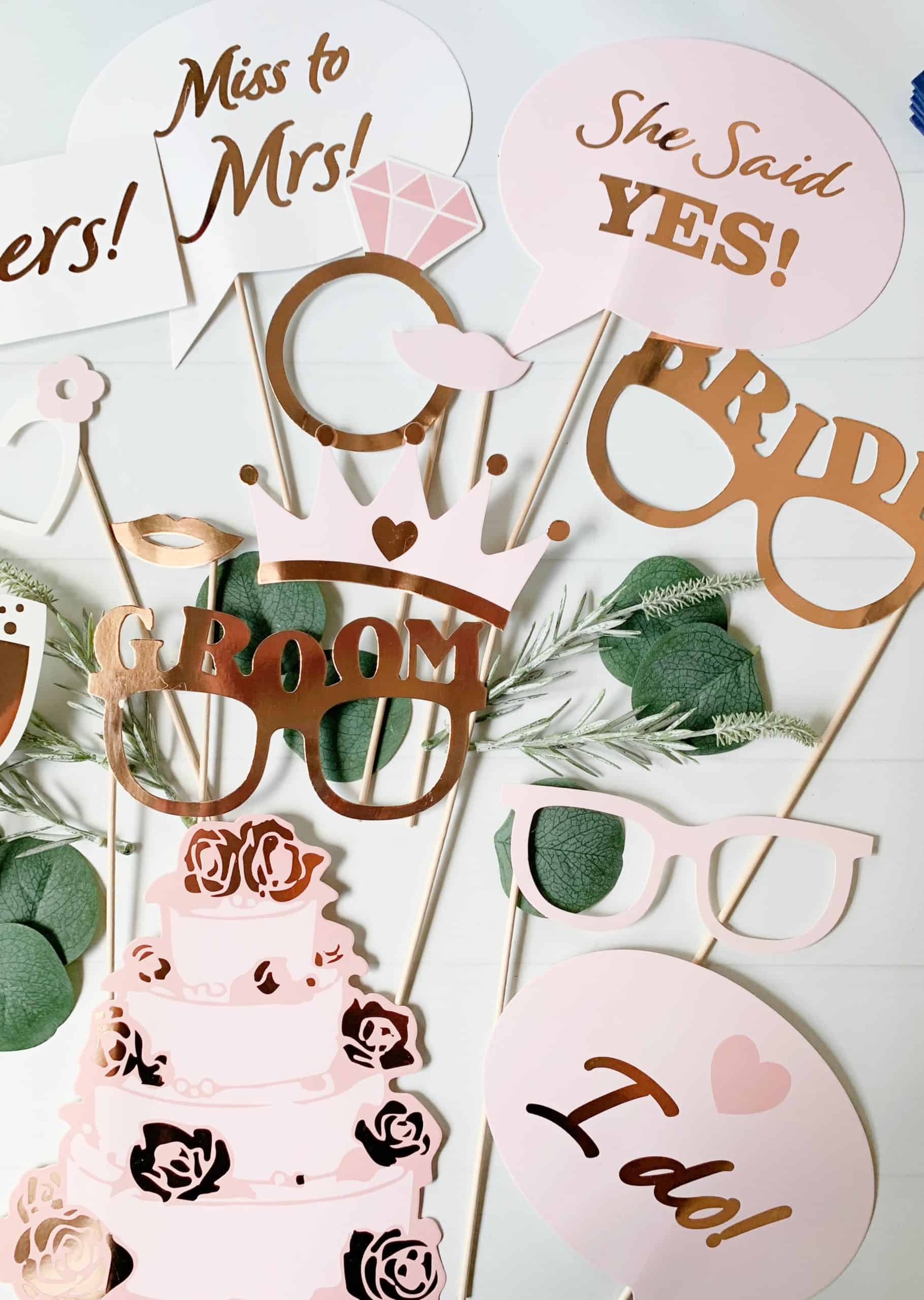Set of 14 Rose Gold Wedding or Bridal Shower Photo Props, made of high-quality cardstock with rose gold foil details, mounted on wooden dowels for easy handling and photographing.